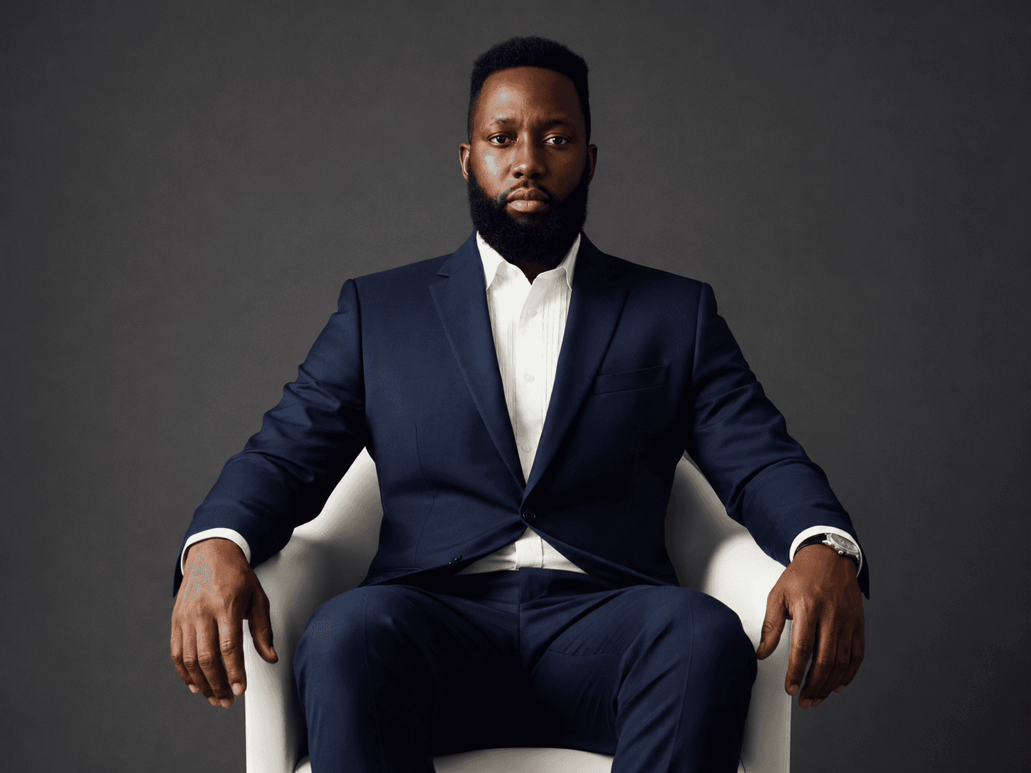 Nick Martin, founder of Nick Martin Builds, seated in a navy suit for a professional brand portrait.